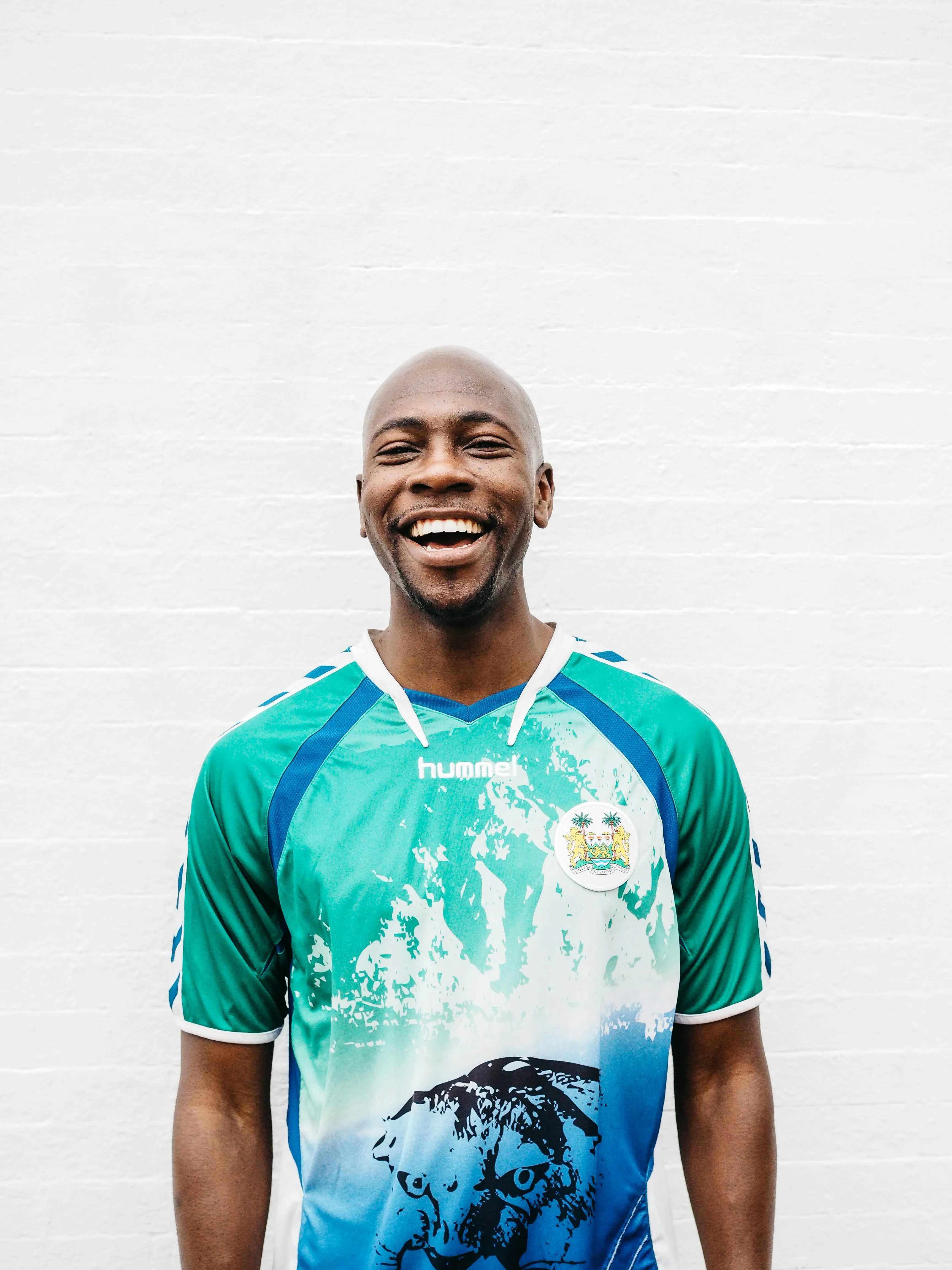 Smiling man in green athletic shirt, close up portrait