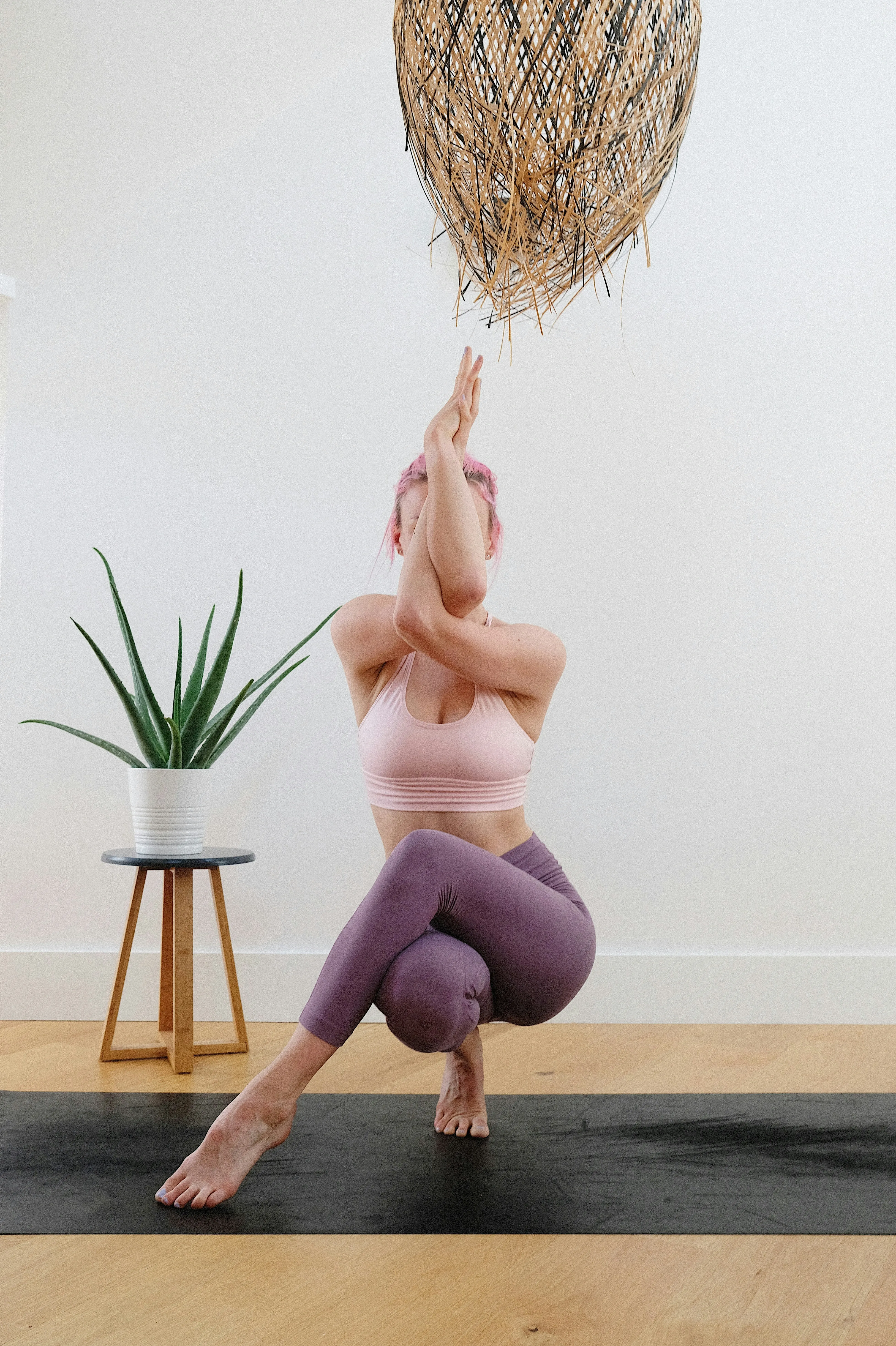 Woman in twisted yoga pose on mat